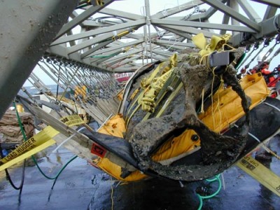 Le hunley remonté en surface tenu par les harnais sous le portique : Vue de la poupe